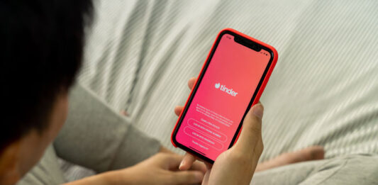 Tinder Mann mit Handy in der Hand