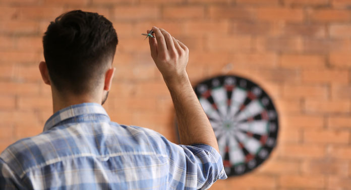 Mann spielt Dart
