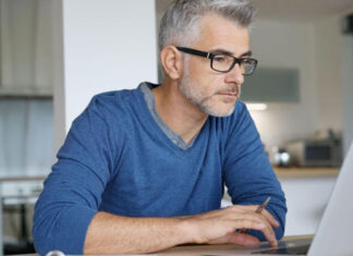Mann mit Blaulichtfilter-Brille am Laptop